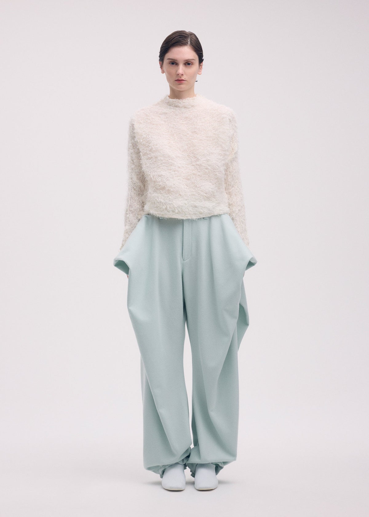 A model wears the ISSEY MIYAKE SHIFTED FUZZY PLEATS shirt.