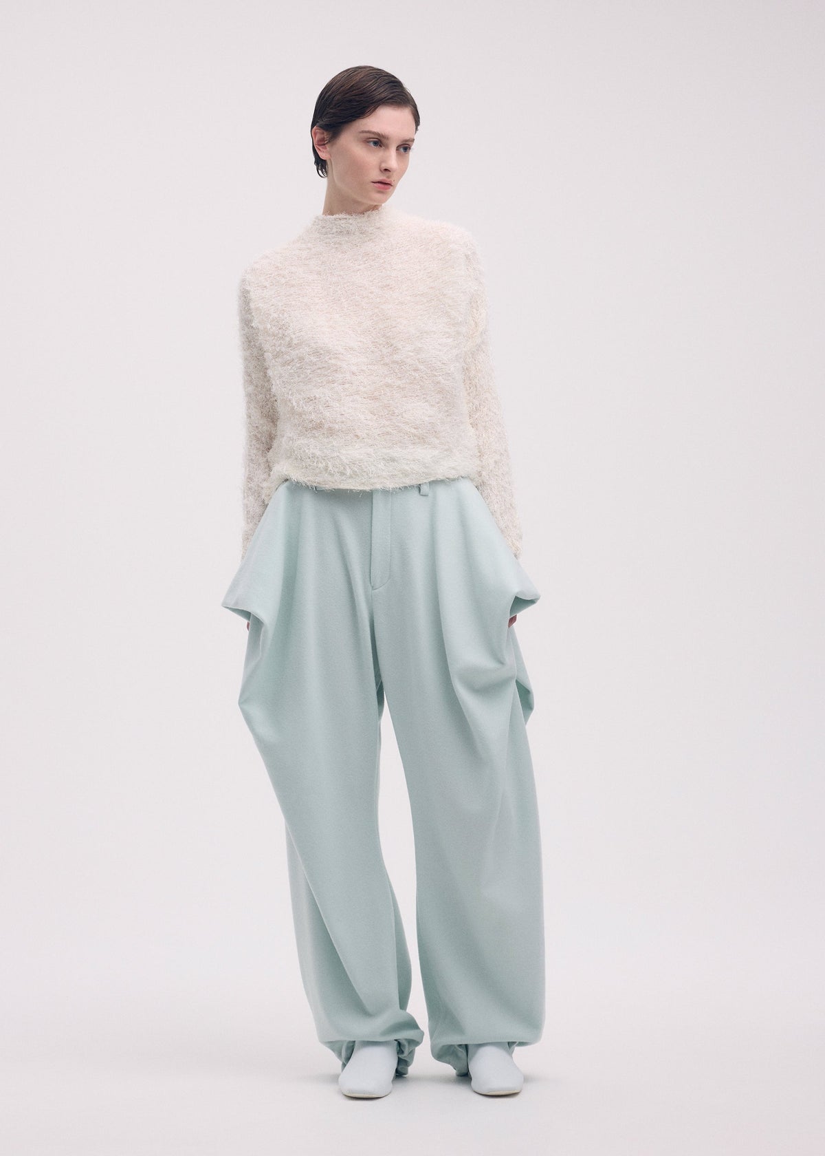 A model wears the ISSEY MIYAKE SHIFTED FUZZY PLEATS shirt.