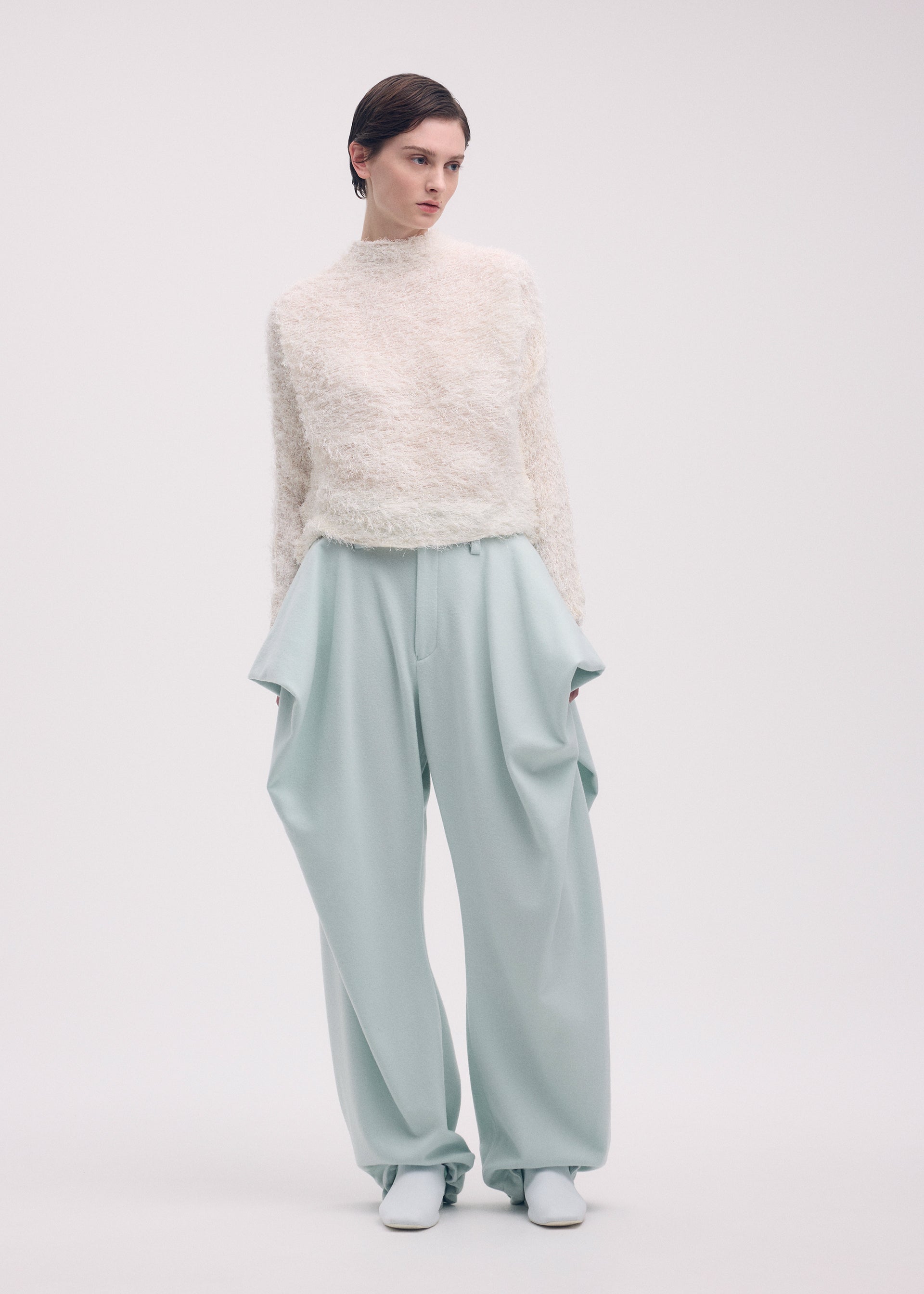 A model wears the ISSEY MIYAKE SHIFTED FUZZY PLEATS shirt.