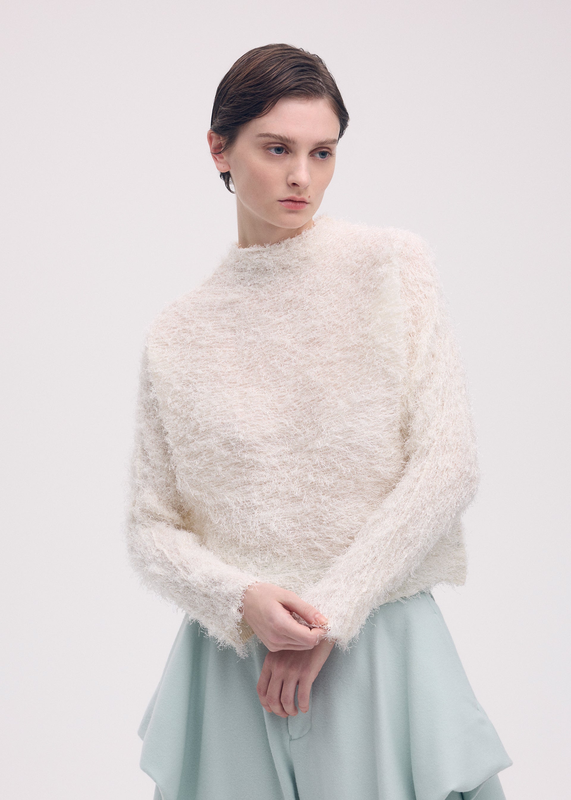 A model wears the ISSEY MIYAKE SHIFTED FUZZY PLEATS shirt.