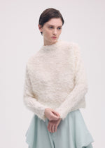 A model wears the ISSEY MIYAKE SHIFTED FUZZY PLEATS shirt.