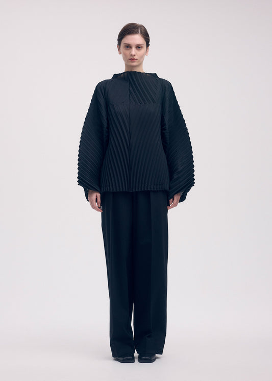 A model wears the ISSEY MIYAKE WAVE PLEATS shirt.