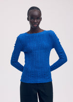 A model wears the ISSEY MIYAKE JELLYFISH PLEATS shirt.