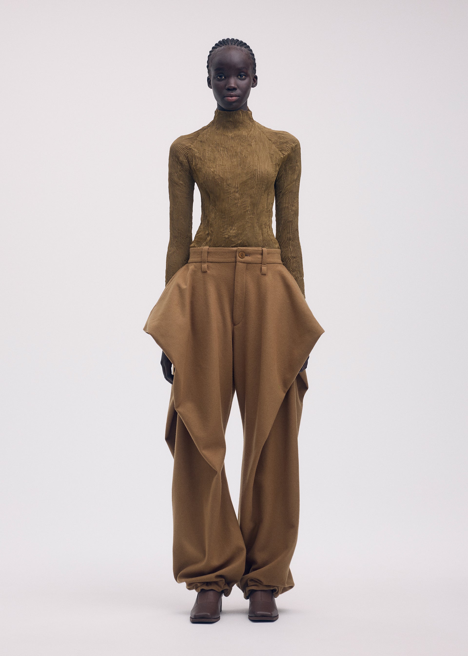 A model wears the ISSEY MIYAKE CHIFFON TWIST 3 clothing.