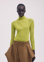 A model wears the ISSEY MIYAKE CHIFFON TWIST 3 clothing.