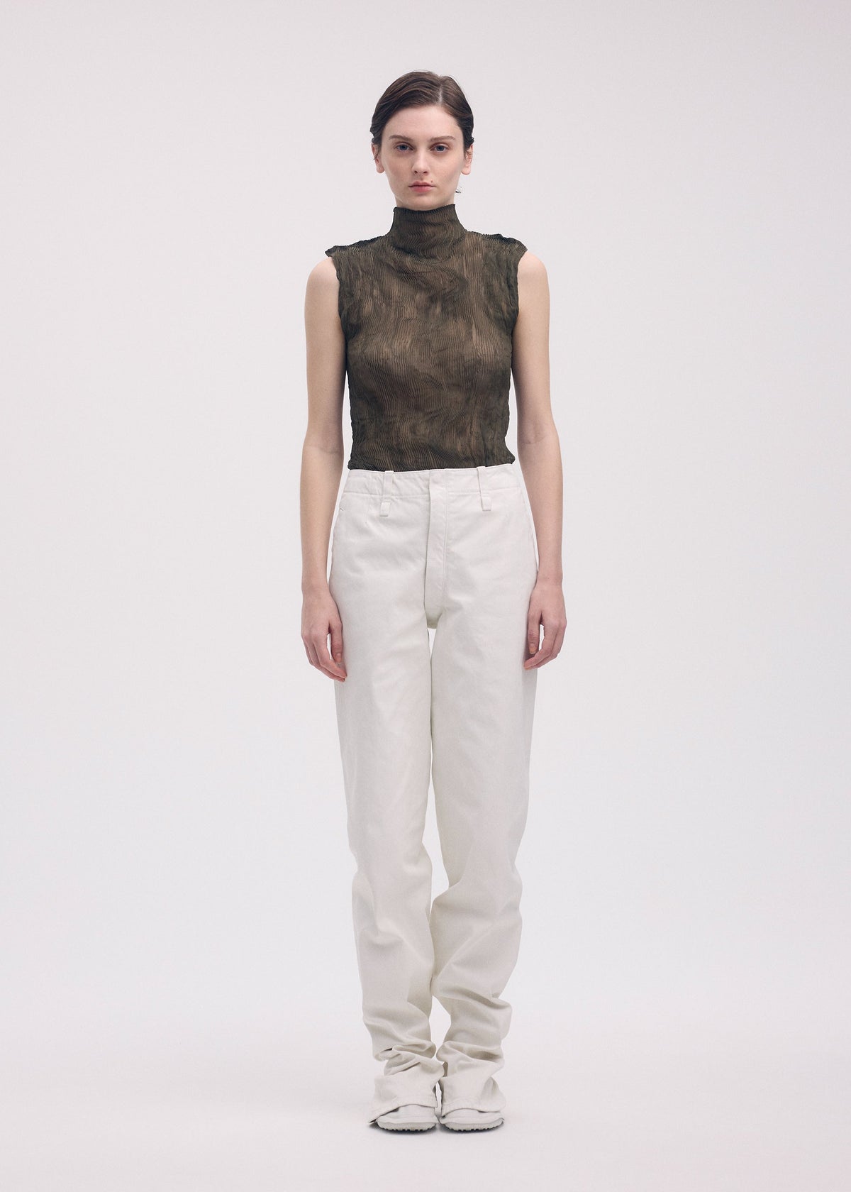 A model wears the ISSEY MIYAKE CHIFFON TWIST 1 top.
