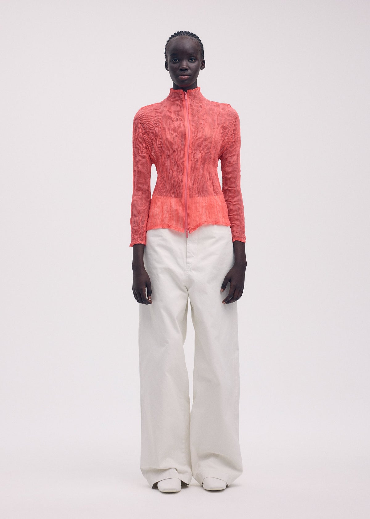 A model wears the ISSEY MIYAKE CHIFFON TWIST 1 top.