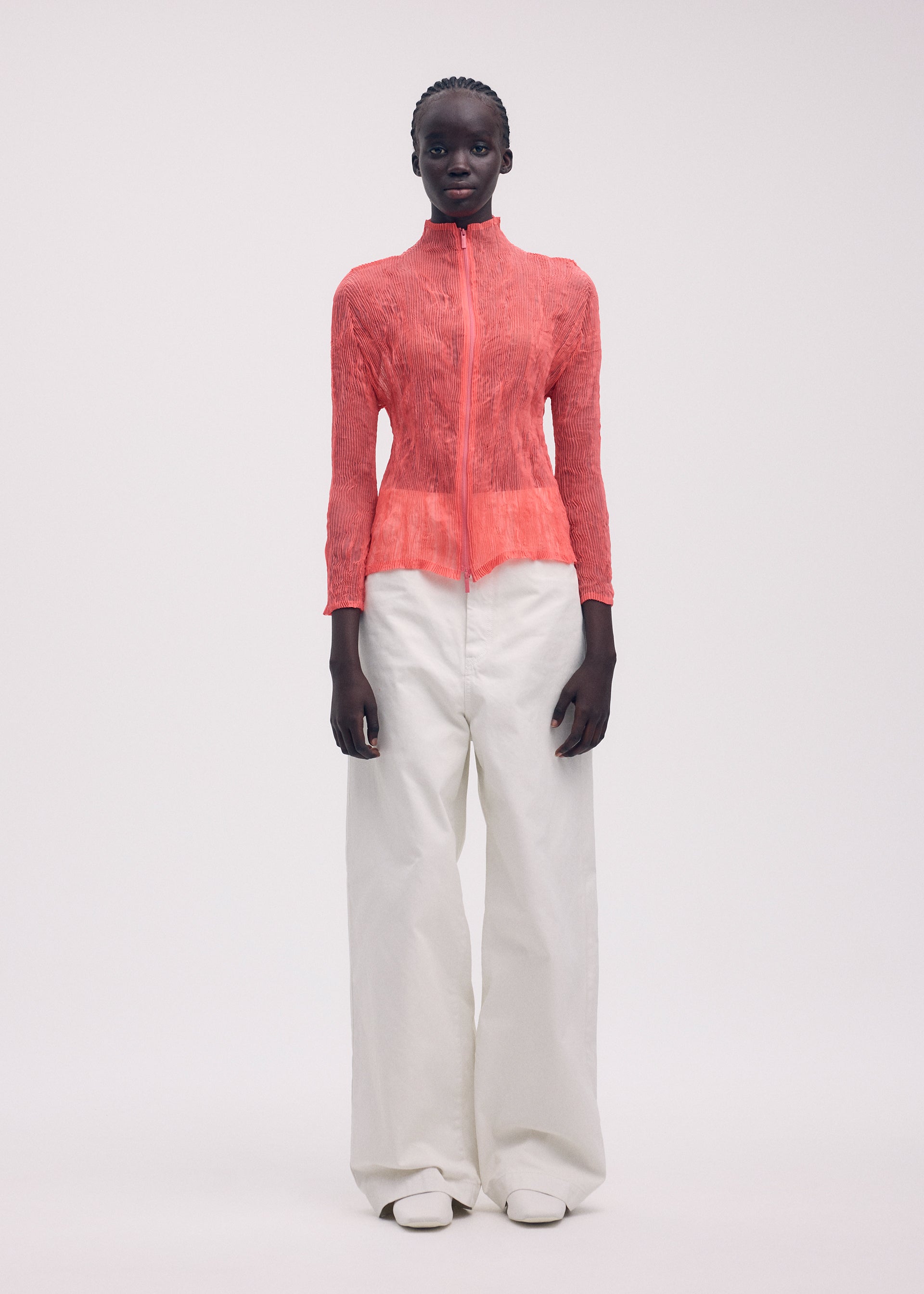 A model wears the ISSEY MIYAKE CHIFFON TWIST 1 top.