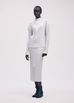 A model wears the ISSEY MIYAKE SLEEK PLEATS cardigan.