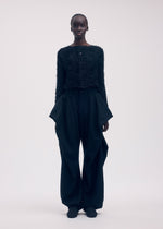 A model wears the ISSEY MIYAKE SHIFTED FUZZY PLEATS cardigan.