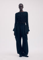 A model wears the ISSEY MIYAKE SHIFTED FUZZY PLEATS cardigan.