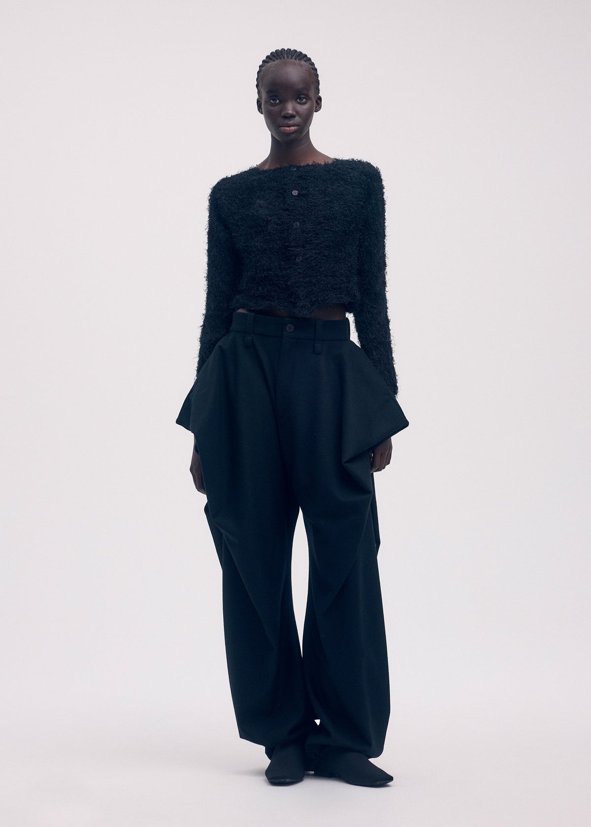 A model wears the ISSEY MIYAKE SHIFTED FUZZY PLEATS cardigan.