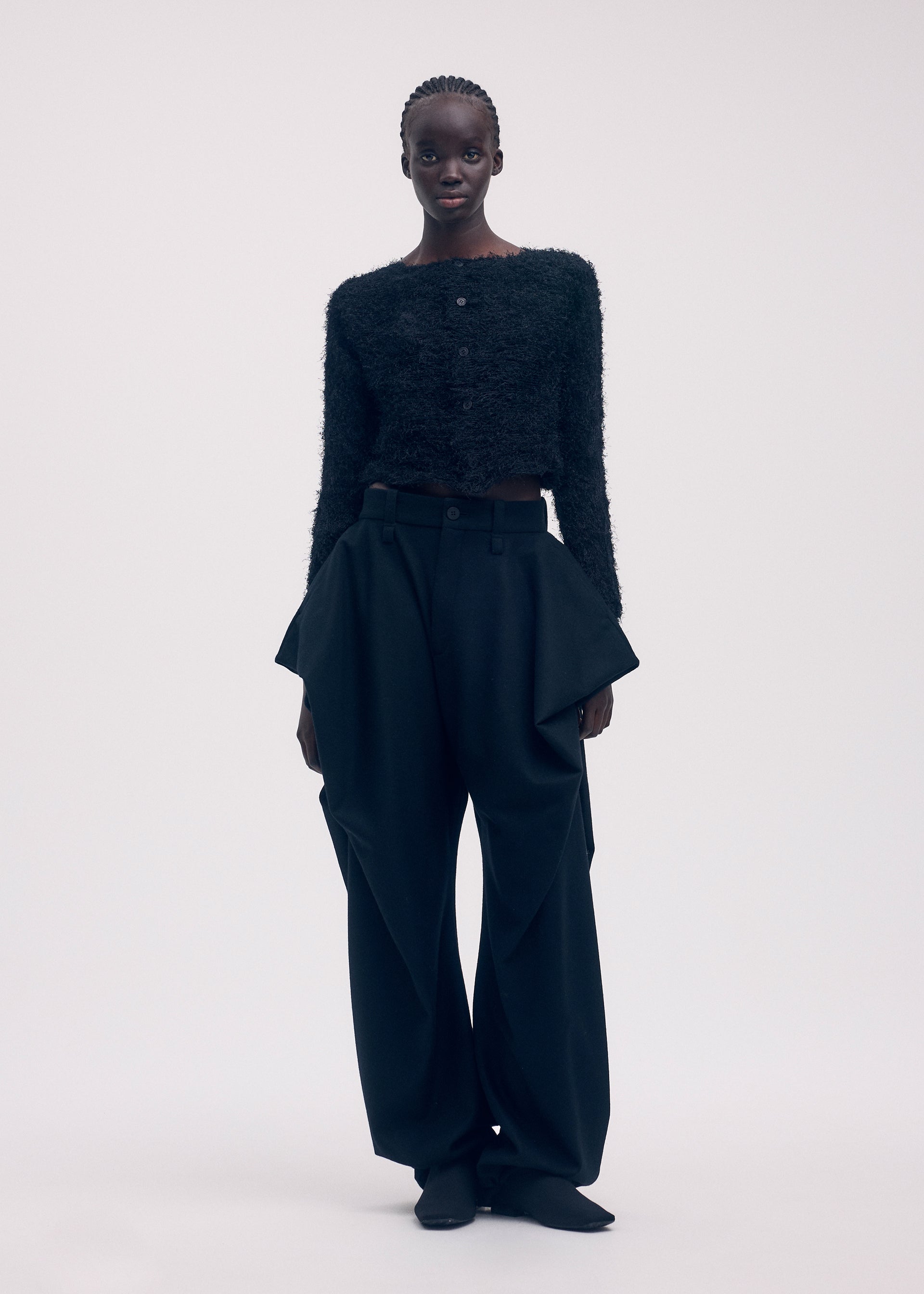 A model wears the ISSEY MIYAKE SHIFTED FUZZY PLEATS cardigan.