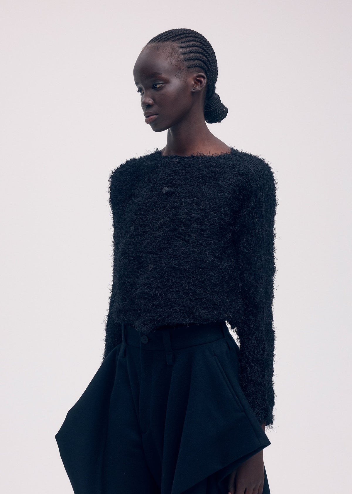 A model wears the ISSEY MIYAKE SHIFTED FUZZY PLEATS cardigan.