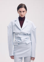 A model wears the ISSEY MIYAKE LIKE TORSO LIKE BLAZER tunic.