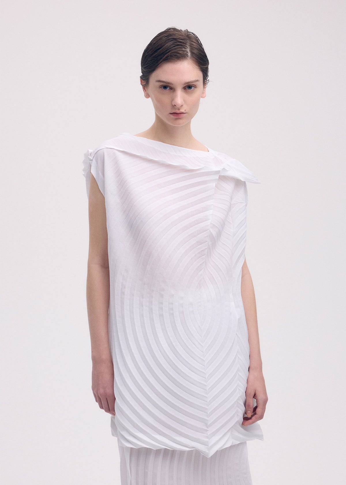 A model wears the ISSEY MIYAKE PAPER BAG PLEATS tunic.