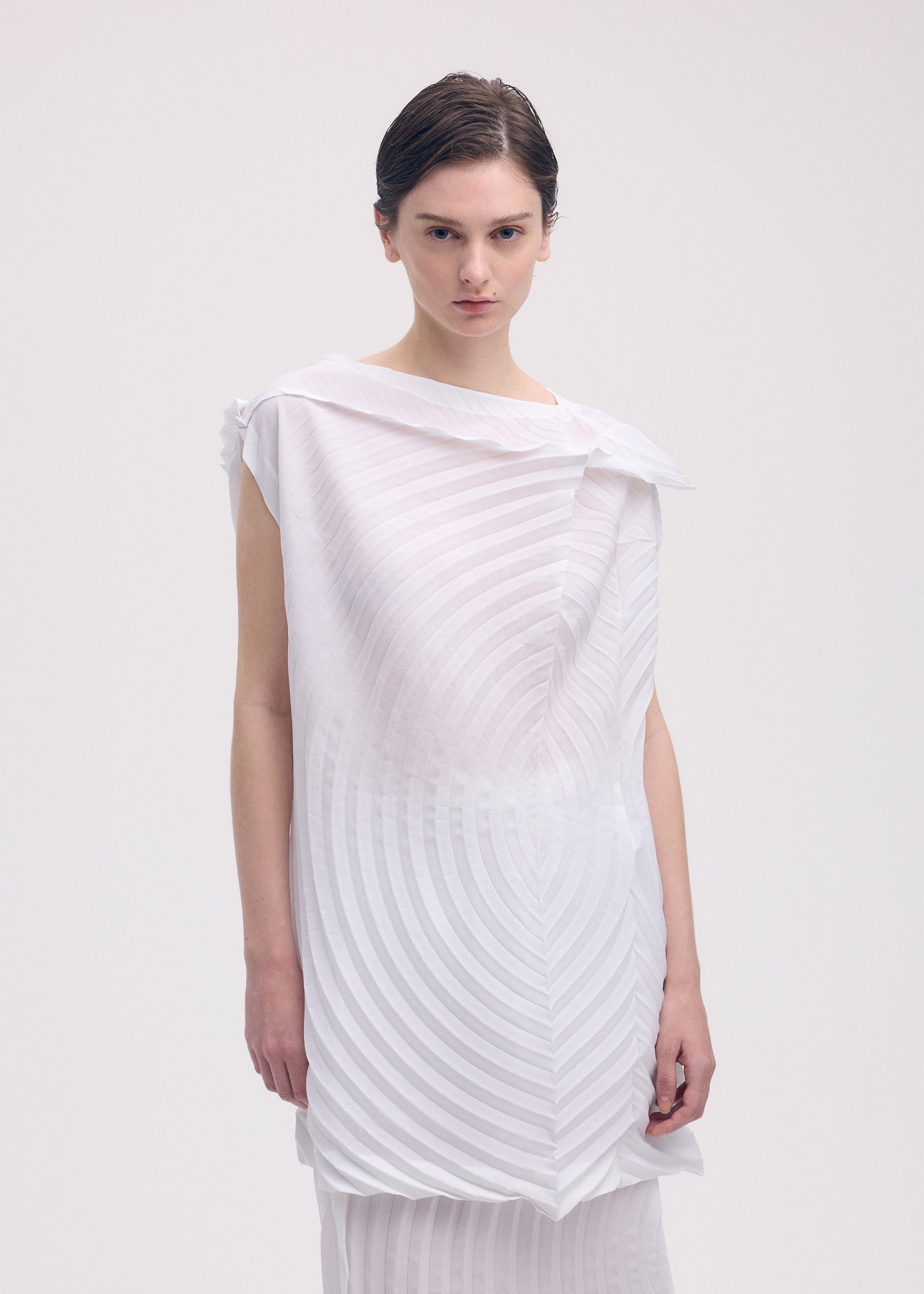 A model wears the ISSEY MIYAKE PAPER BAG PLEATS tunic.