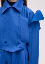 A model wears the ISSEY MIYAKE LEFT UNDONE coat.
