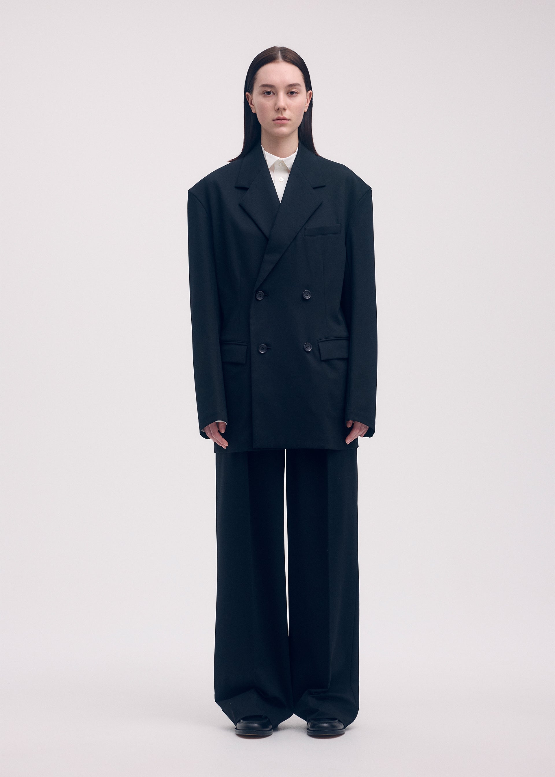 A model wears the ISSEY MIYAKE SIMPLE ENSEMBLE trousers.