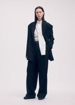 A model wears the ISSEY MIYAKE SIMPLE ENSEMBLE trousers.