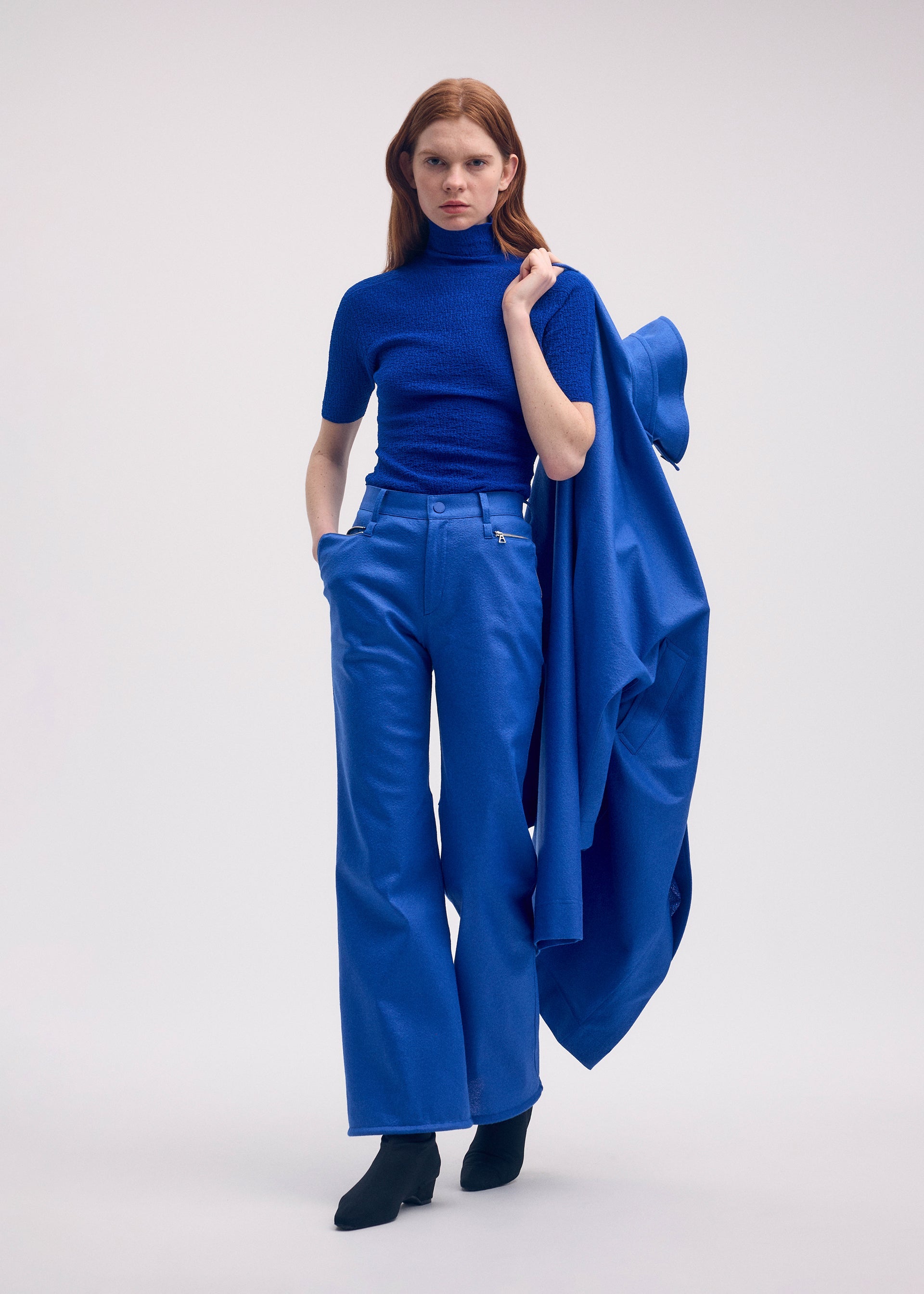 A model wears the ISSEY MIYAKE HANG OR CARRY trousers.