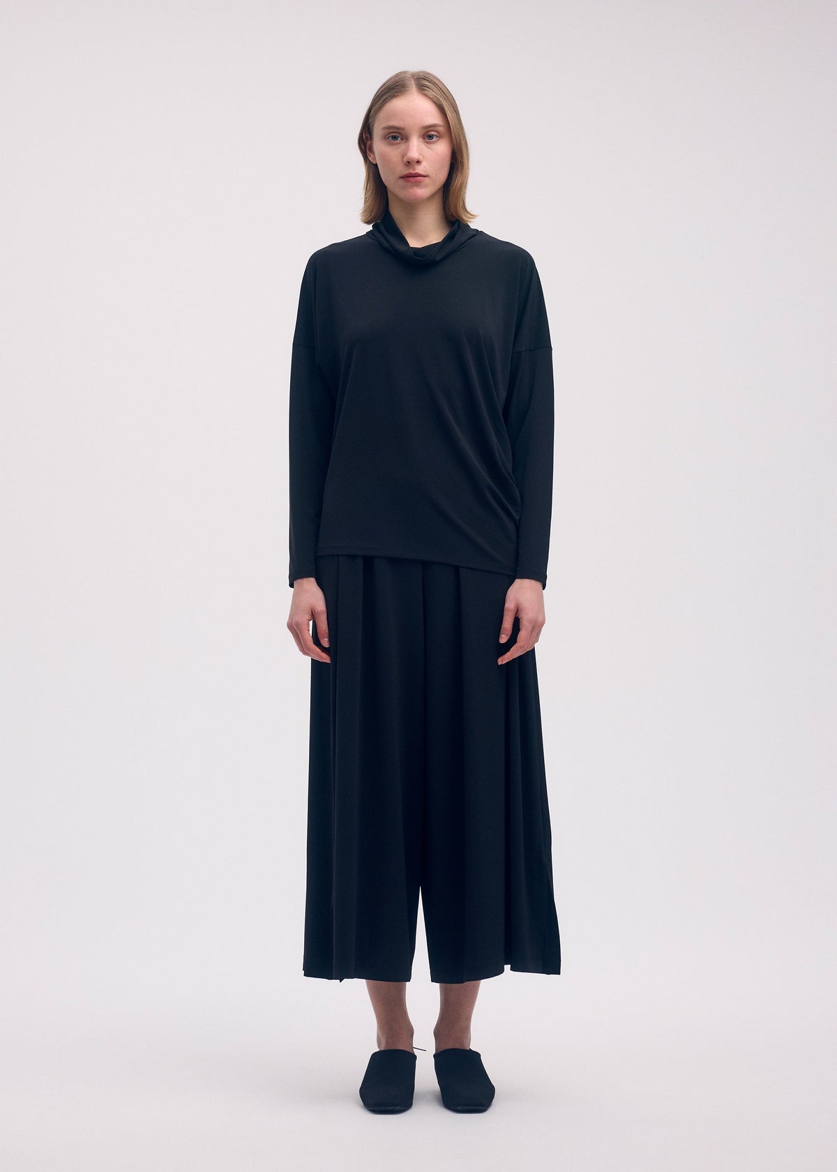 A model wears the ISSEY MIYAKE DRAPE JERSEY 58 top.