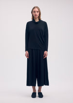 A model wears the ISSEY MIYAKE DRAPE JERSEY 58 top.