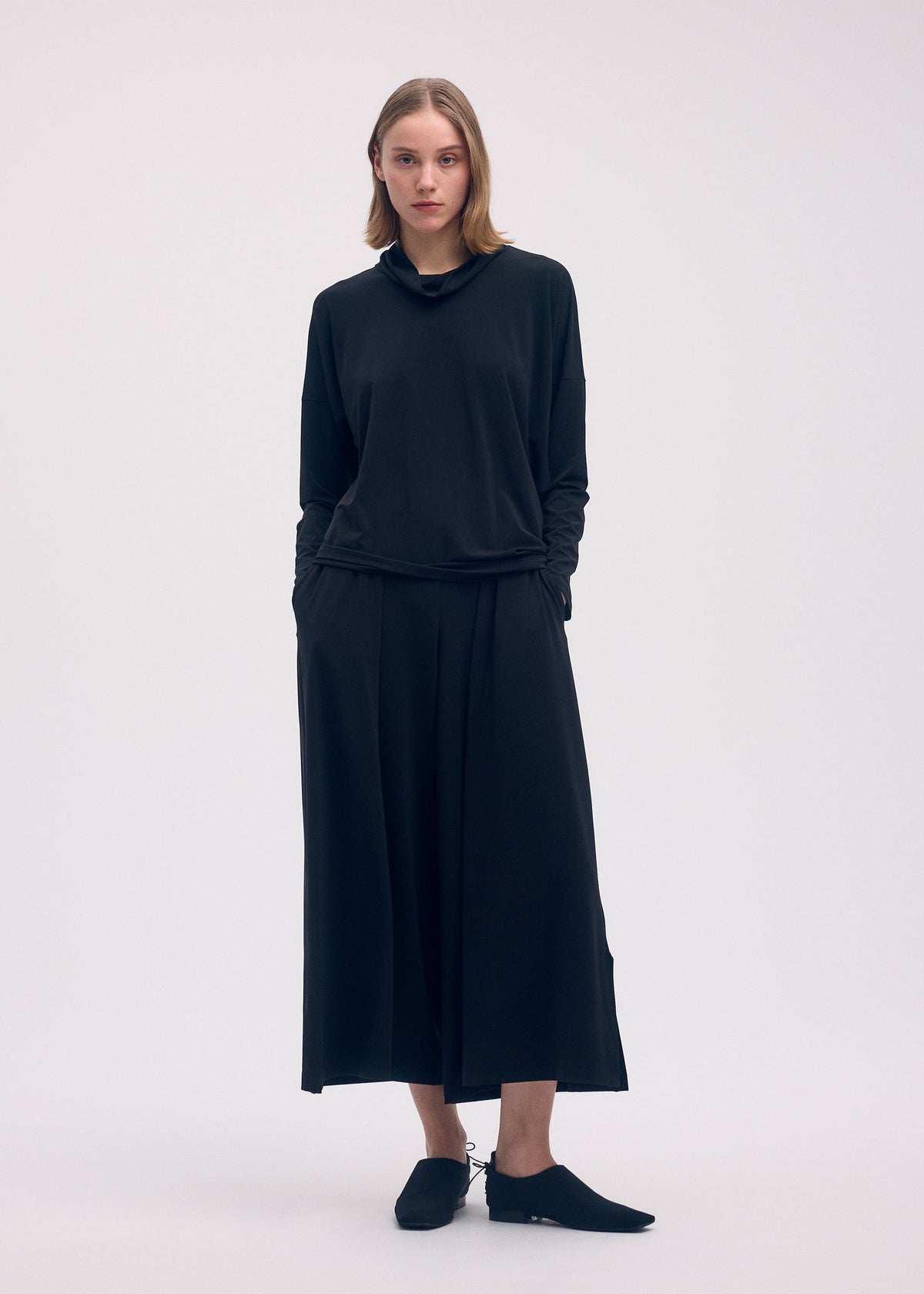 A model wears the ISSEY MIYAKE DRAPE JERSEY 58 top.