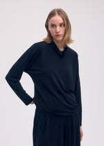 A model wears the ISSEY MIYAKE DRAPE JERSEY 58 top.