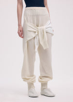 A model wears the ISSEY MIYAKE SLEEVES COLLECTION trousers.