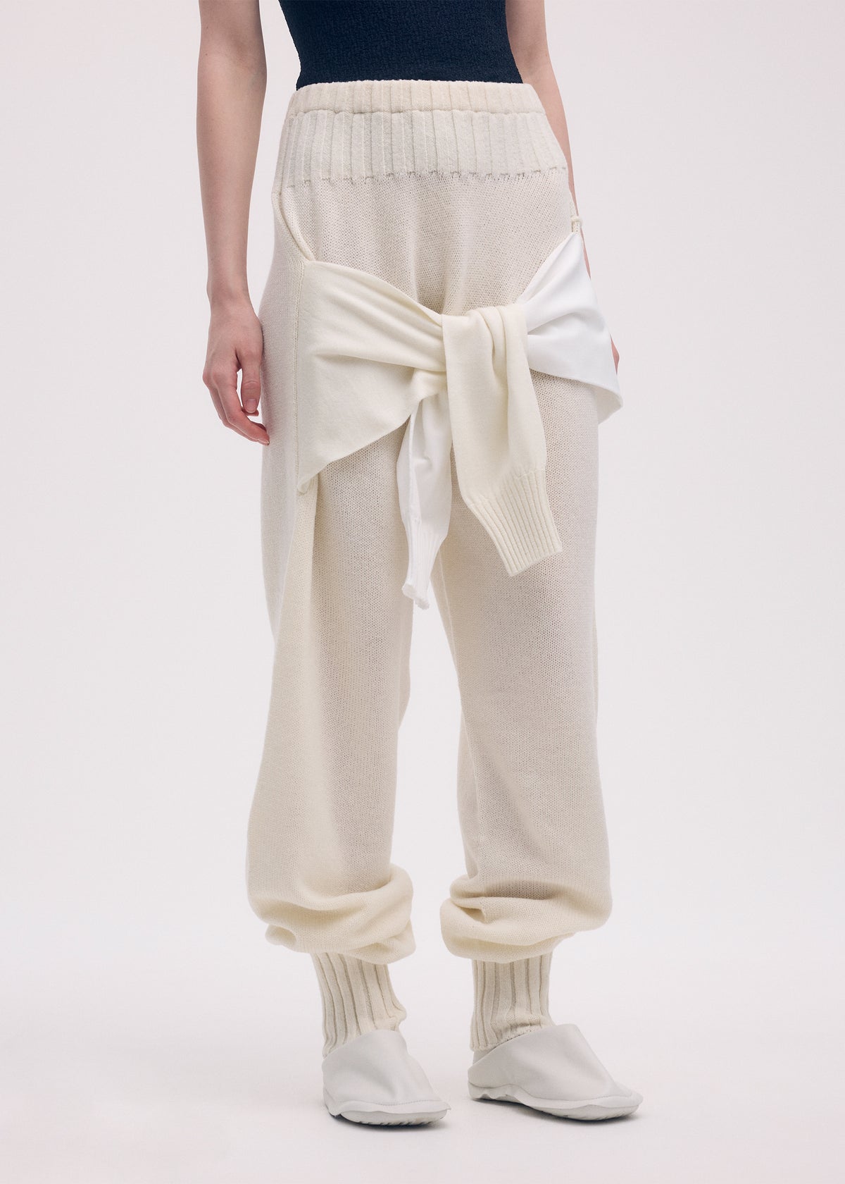 A model wears the ISSEY MIYAKE SLEEVES COLLECTION trousers.