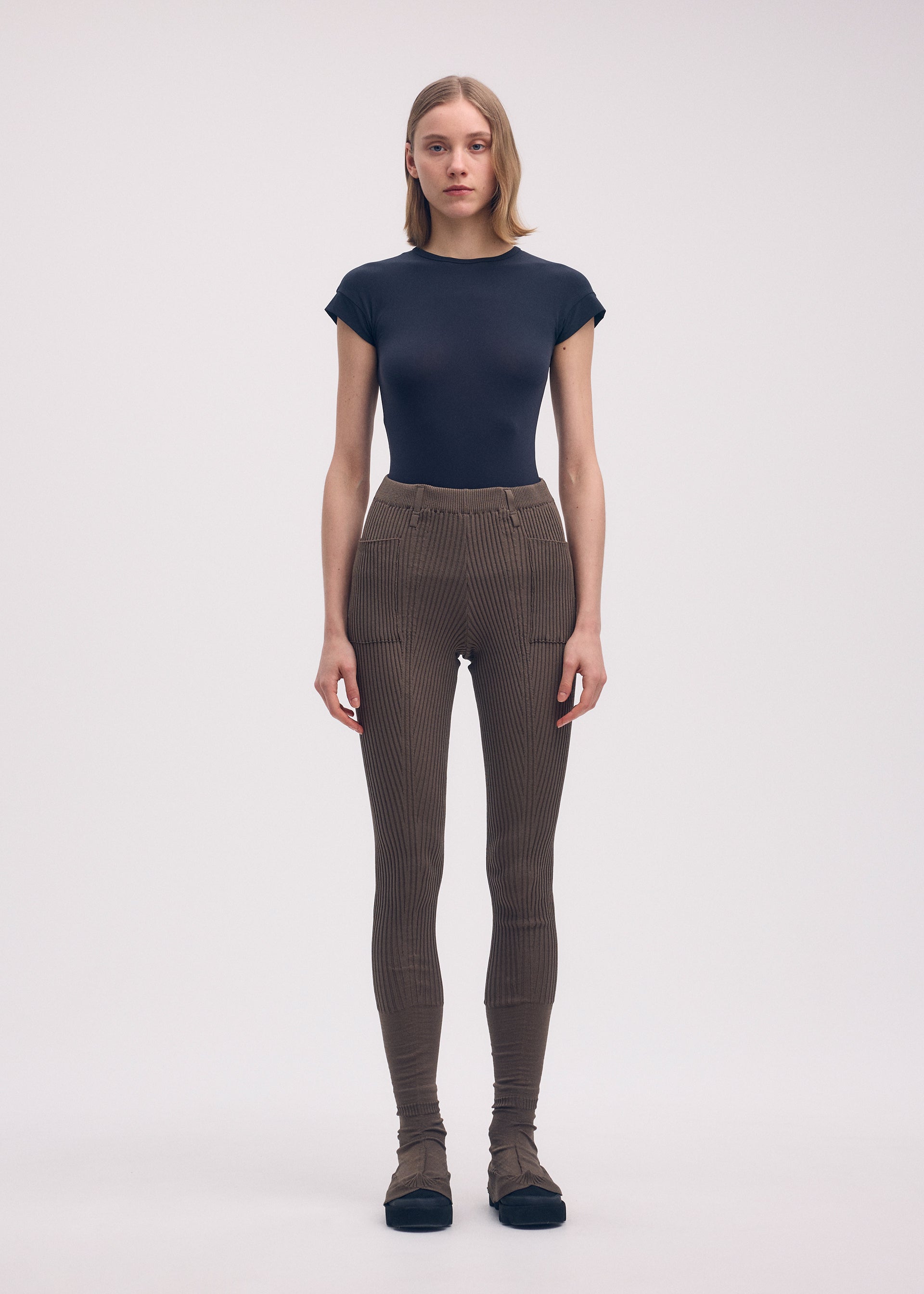 A model wears the ISSEY MIYAKE ODD PANTS trousers.