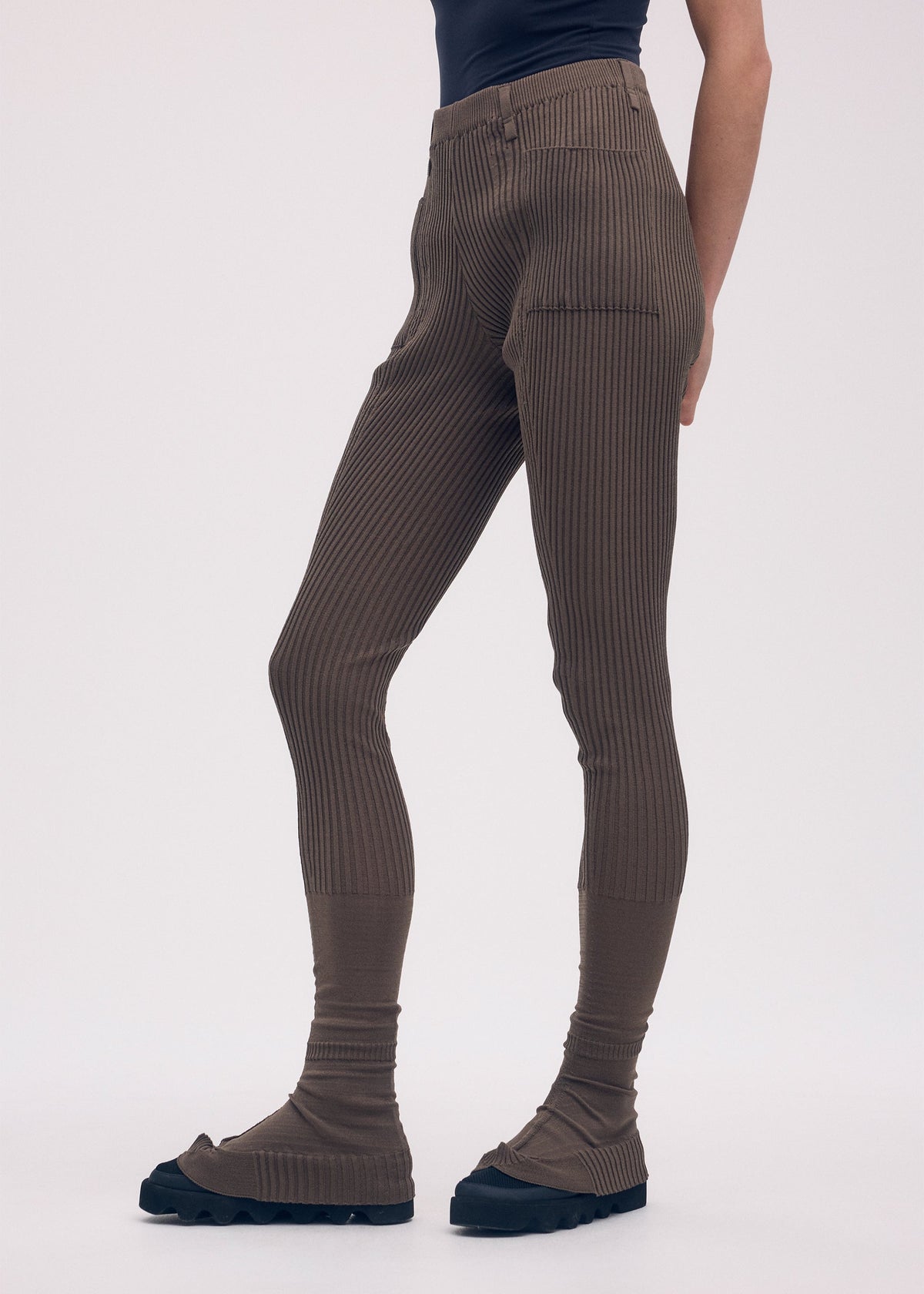 A model wears the ISSEY MIYAKE ODD PANTS trousers.