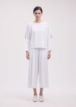 A model wears the ISSEY MIYAKE CAMPAGNE trousers.