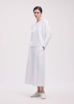 A model wears the ISSEY MIYAKE CAMPAGNE trousers.