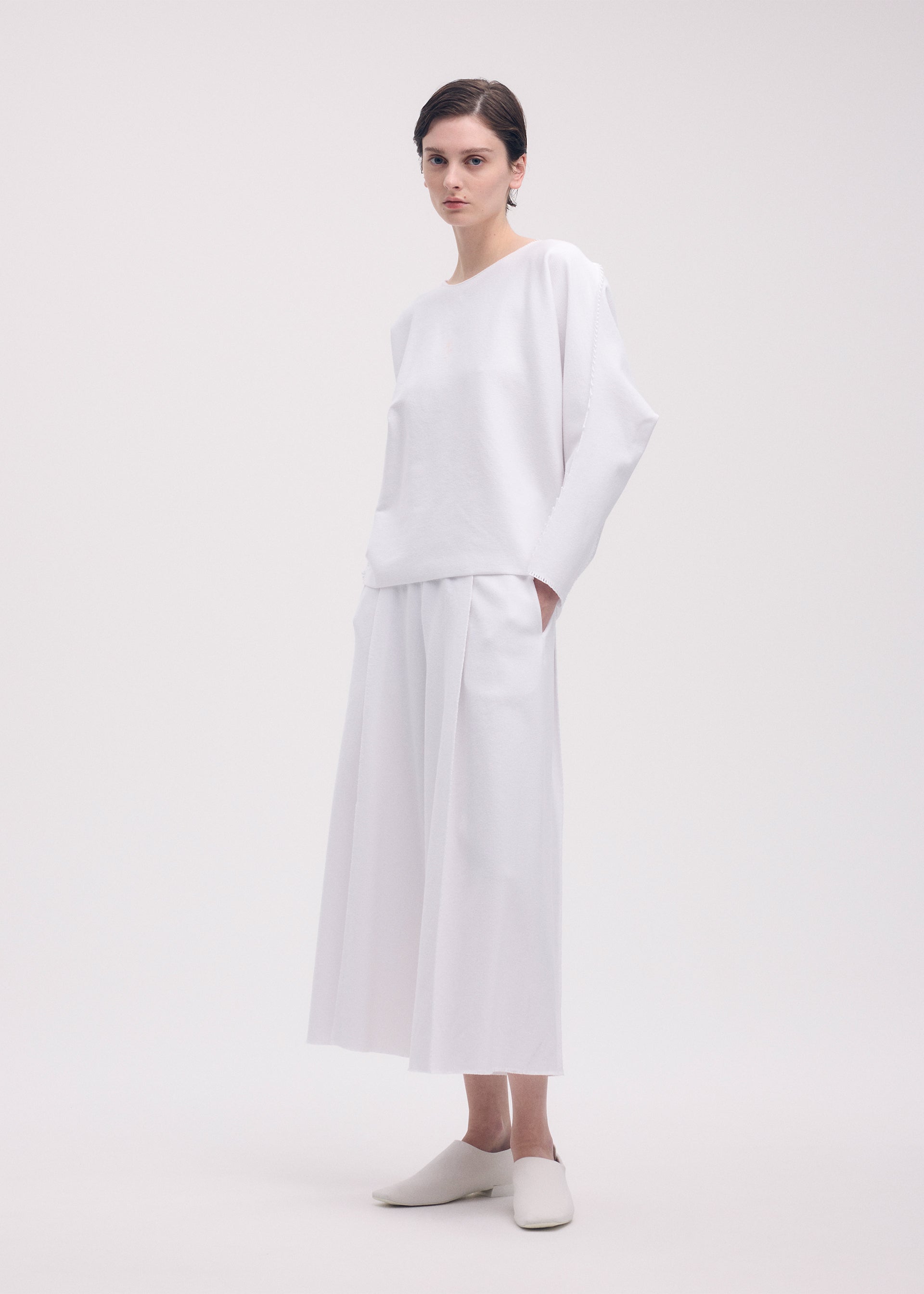 A model wears the ISSEY MIYAKE CAMPAGNE trousers.