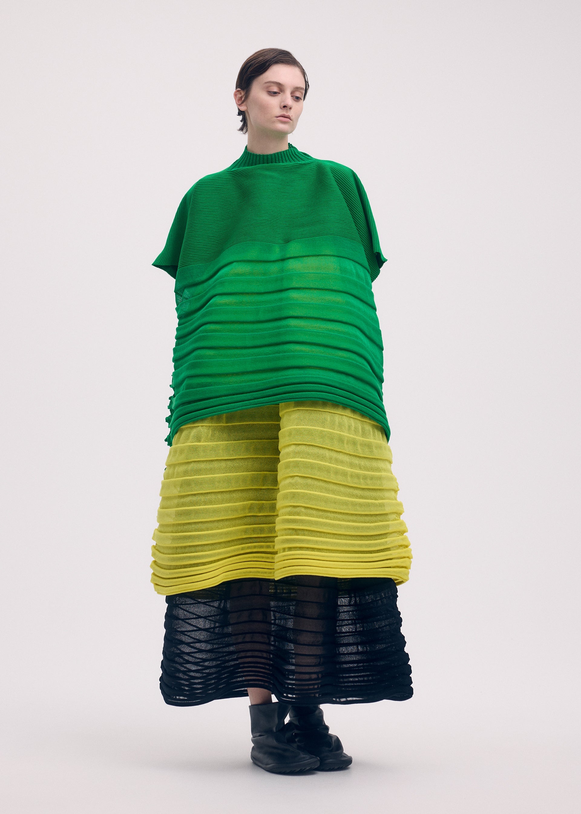 A model wears the ISSEY MIYAKE MOVING KNIT clothing.