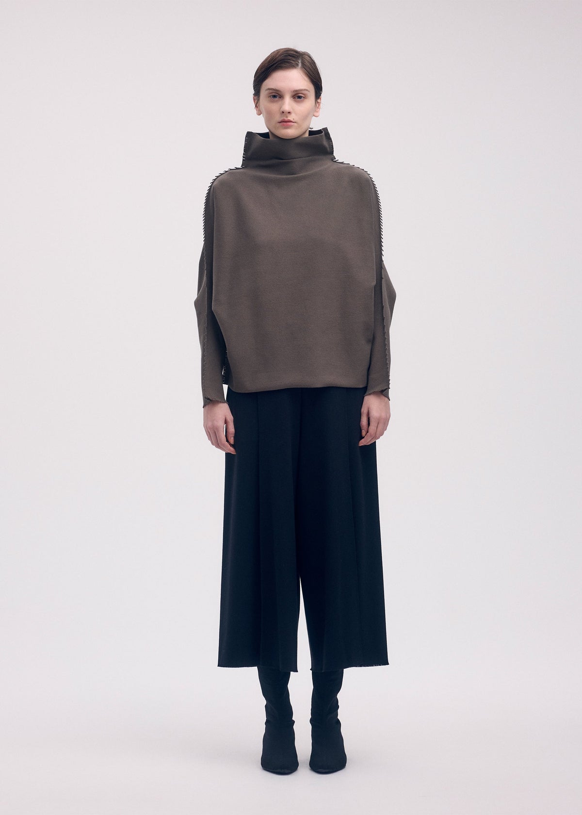 A model wears the ISSEY MIYAKE CAMPAGNE top.