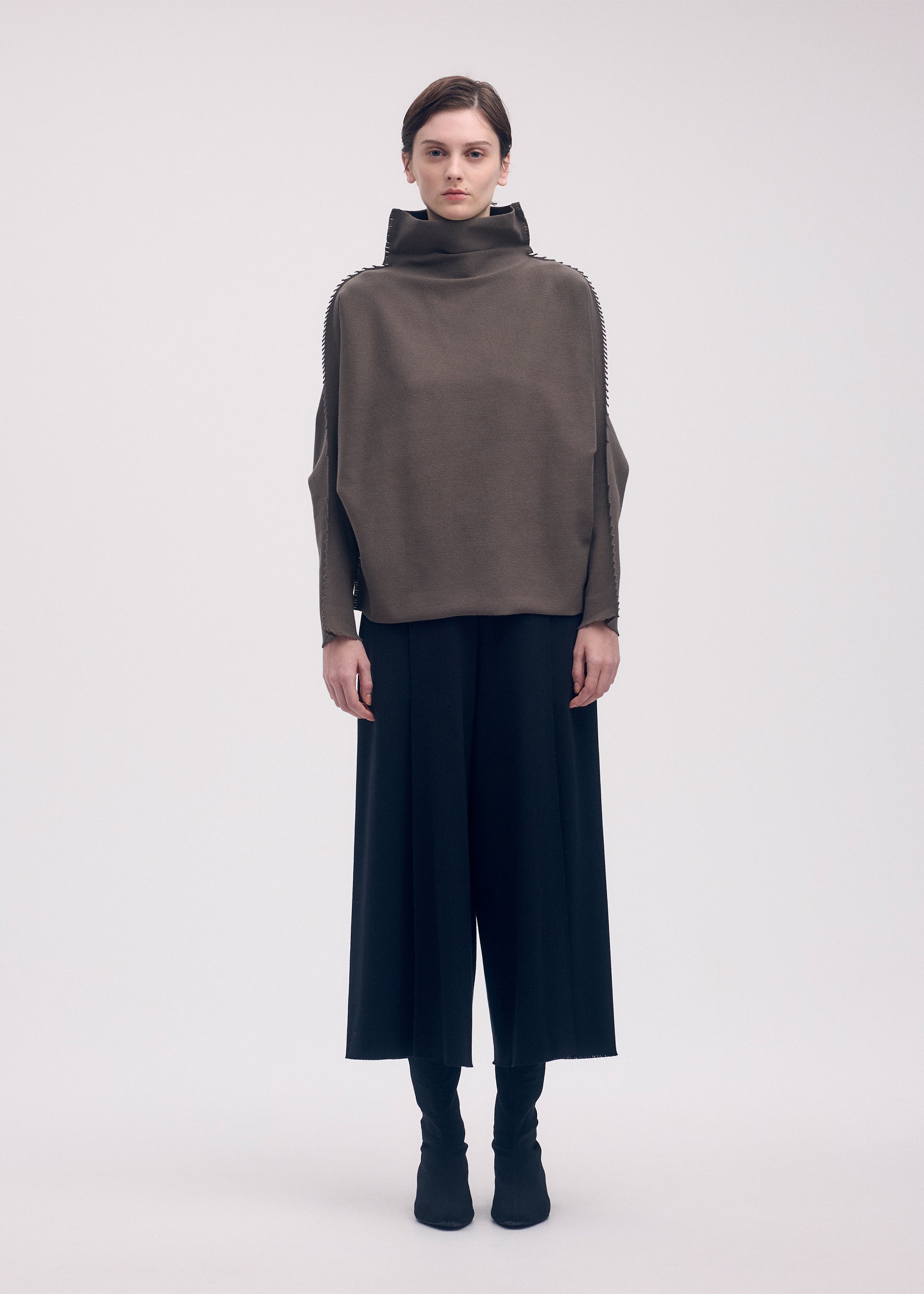 A model wears the ISSEY MIYAKE CAMPAGNE top.