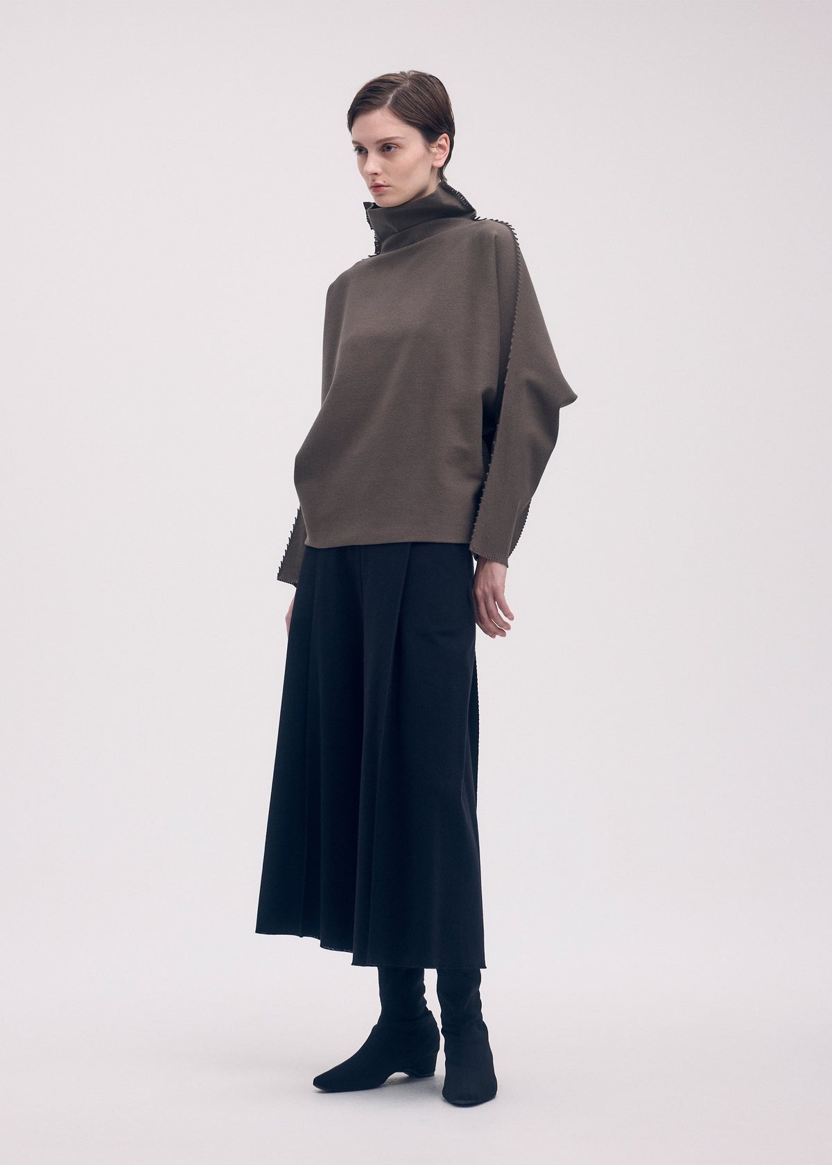 A model wears the ISSEY MIYAKE CAMPAGNE top.