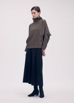 A model wears the ISSEY MIYAKE CAMPAGNE top.