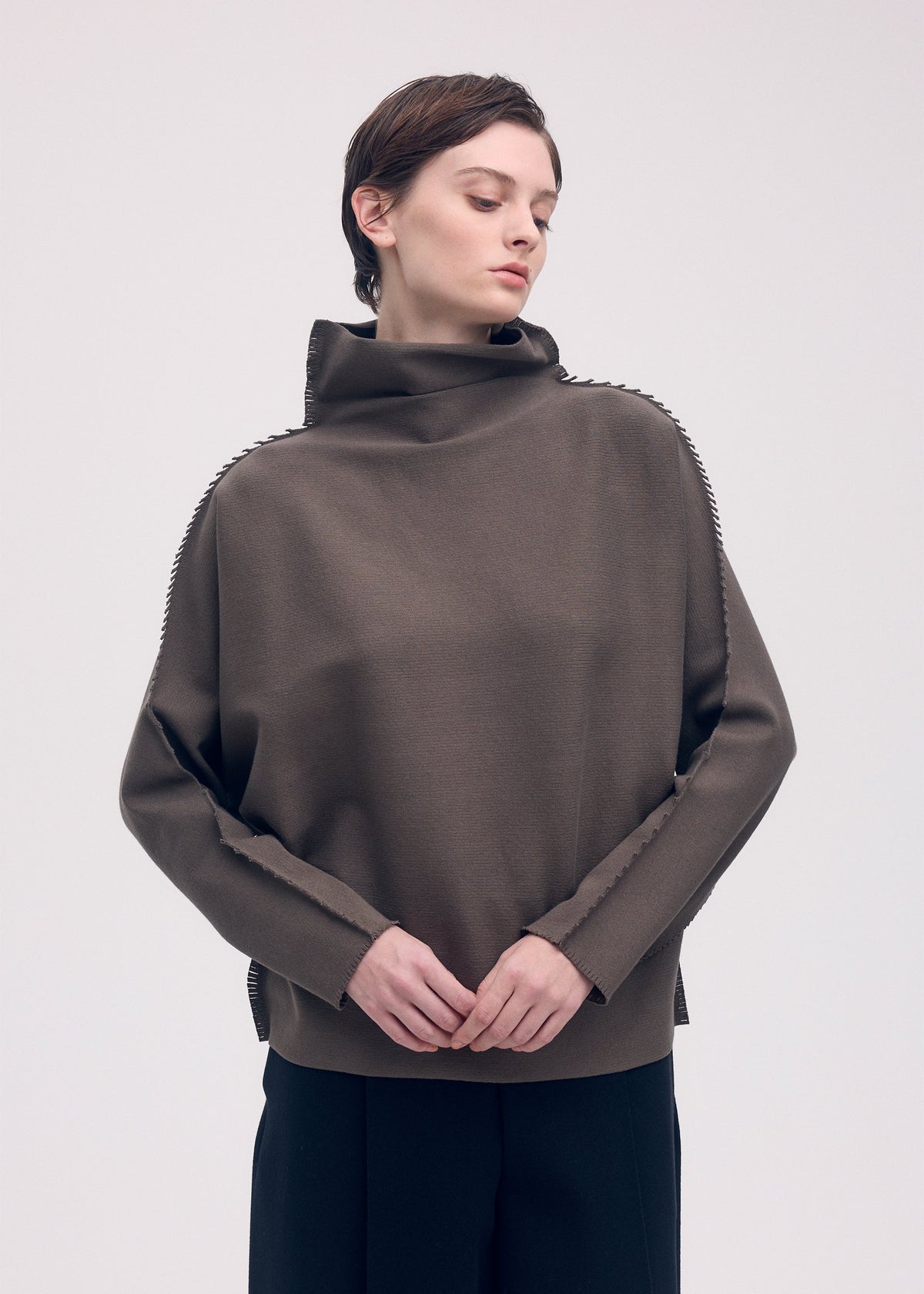 A model wears the ISSEY MIYAKE CAMPAGNE top.