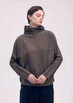 A model wears the ISSEY MIYAKE CAMPAGNE top.