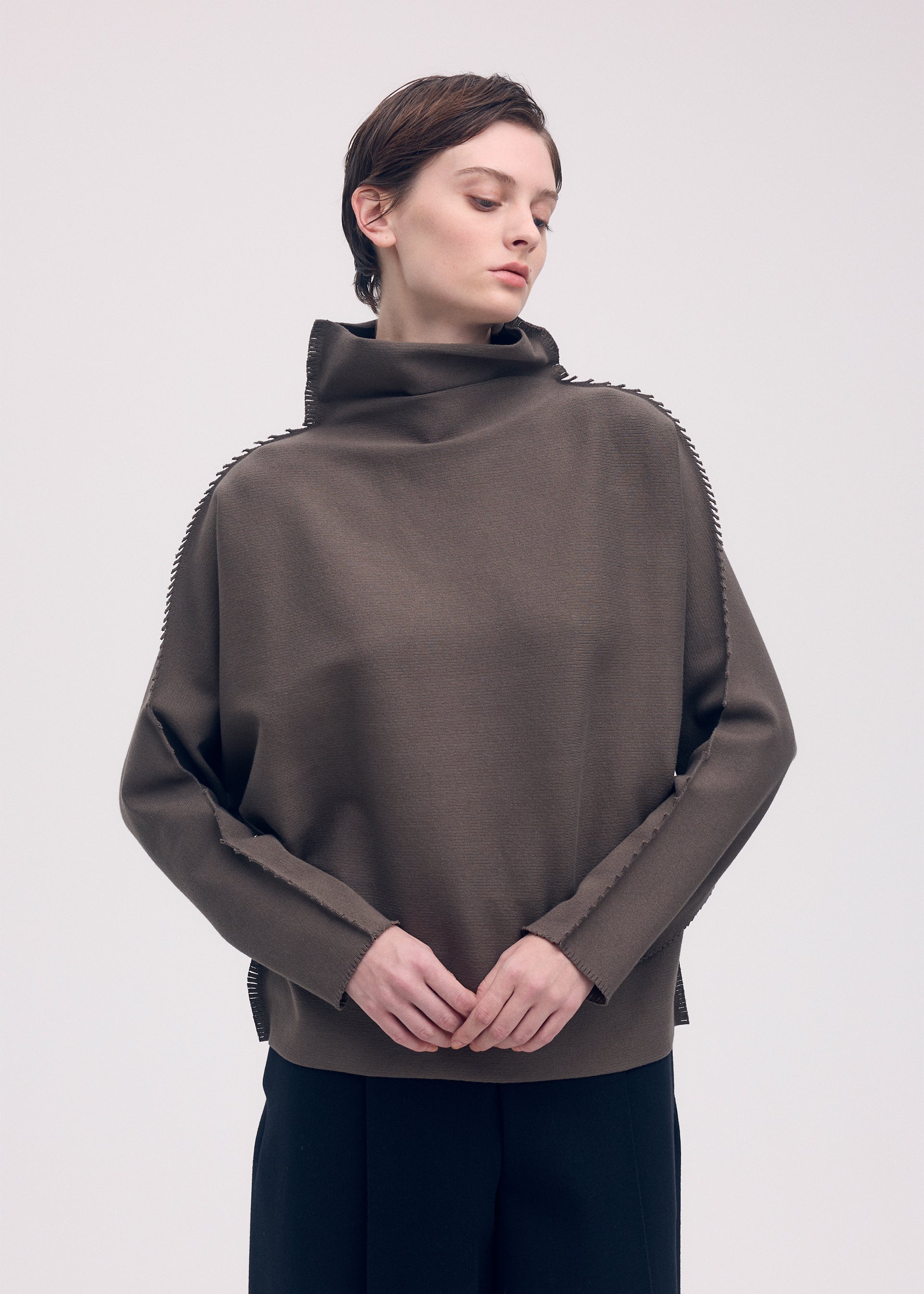 A model wears the ISSEY MIYAKE CAMPAGNE top.