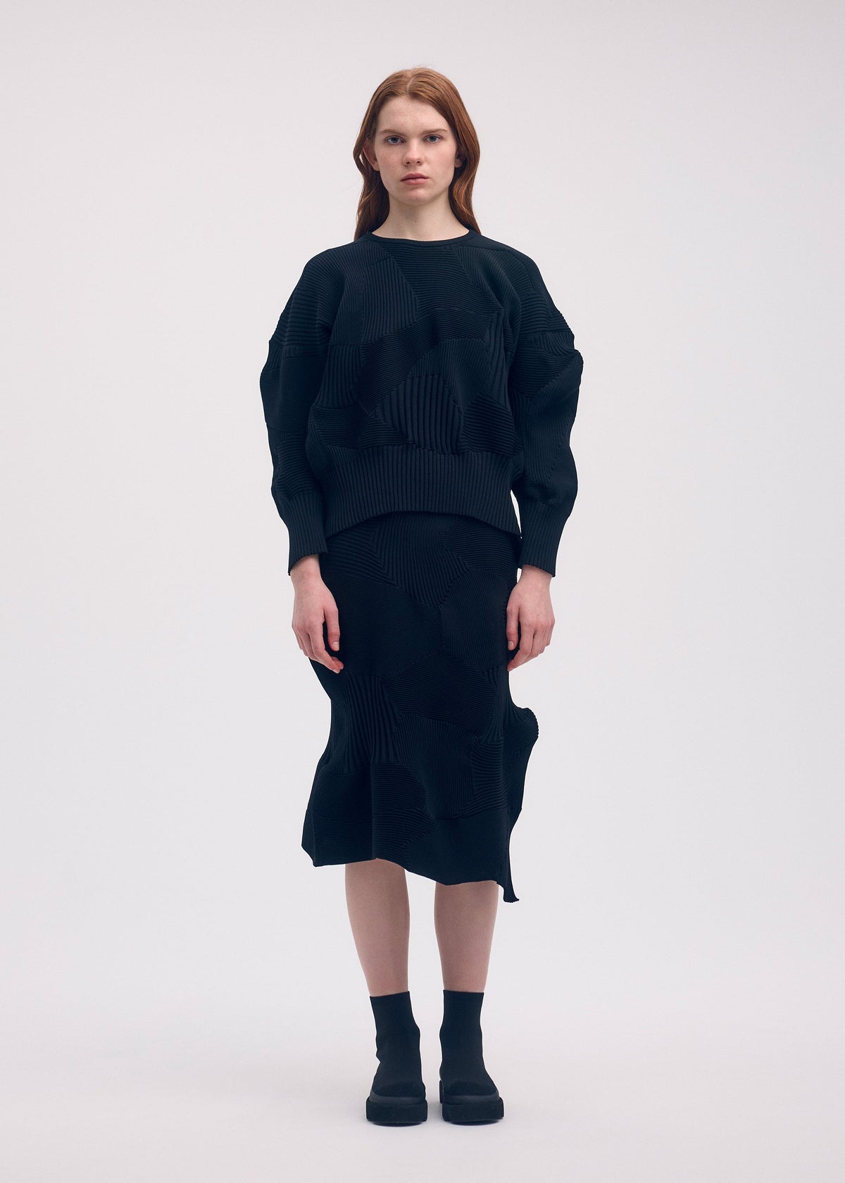 A model wears the ISSEY MIYAKE KONE KONE top.