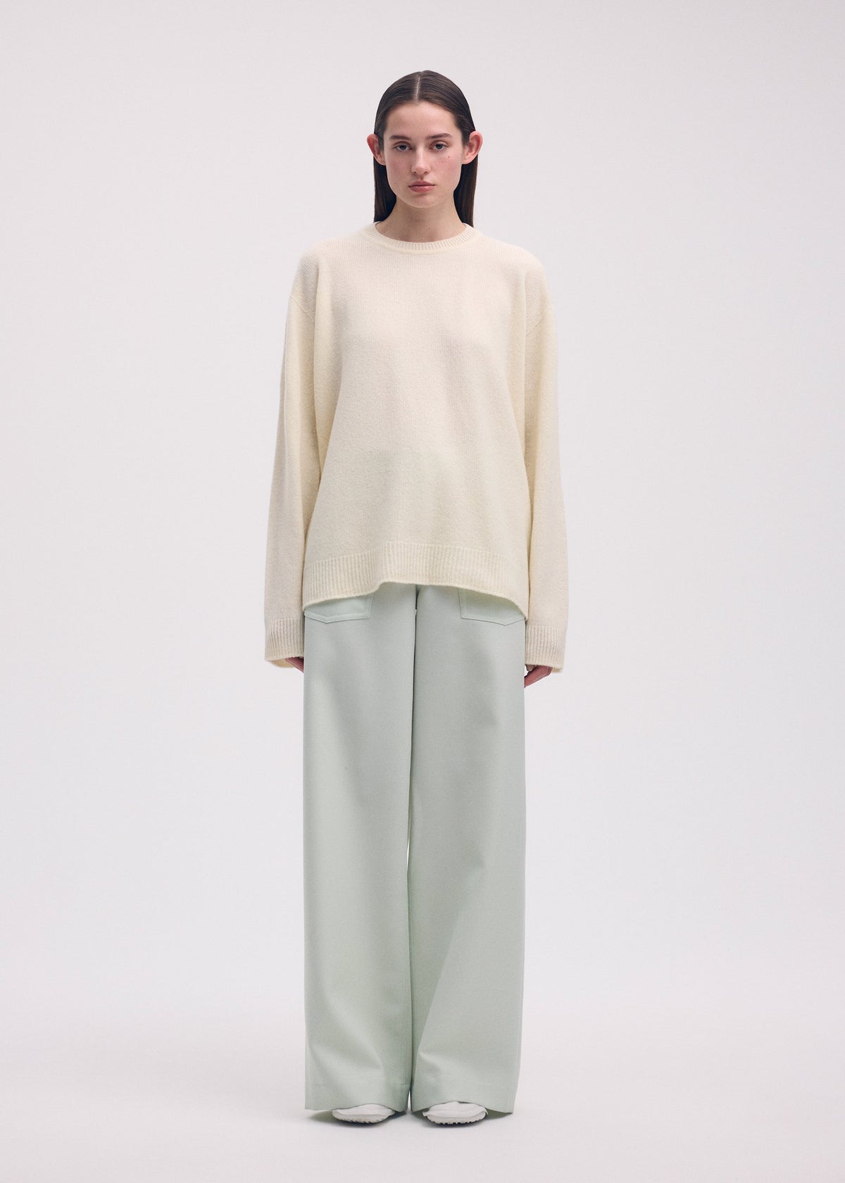 A model wears the ISSEY MIYAKE BACKPACK KNIT top.