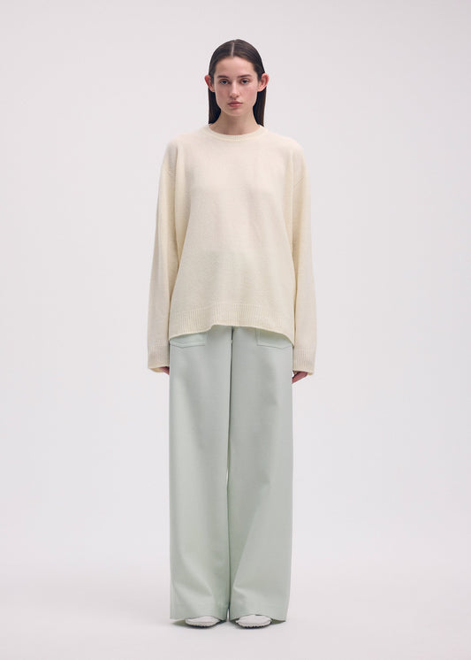 A model wears the ISSEY MIYAKE BACKPACK KNIT top.