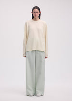 A model wears the ISSEY MIYAKE BACKPACK KNIT top.