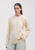 A model wears the ISSEY MIYAKE BACKPACK KNIT top.