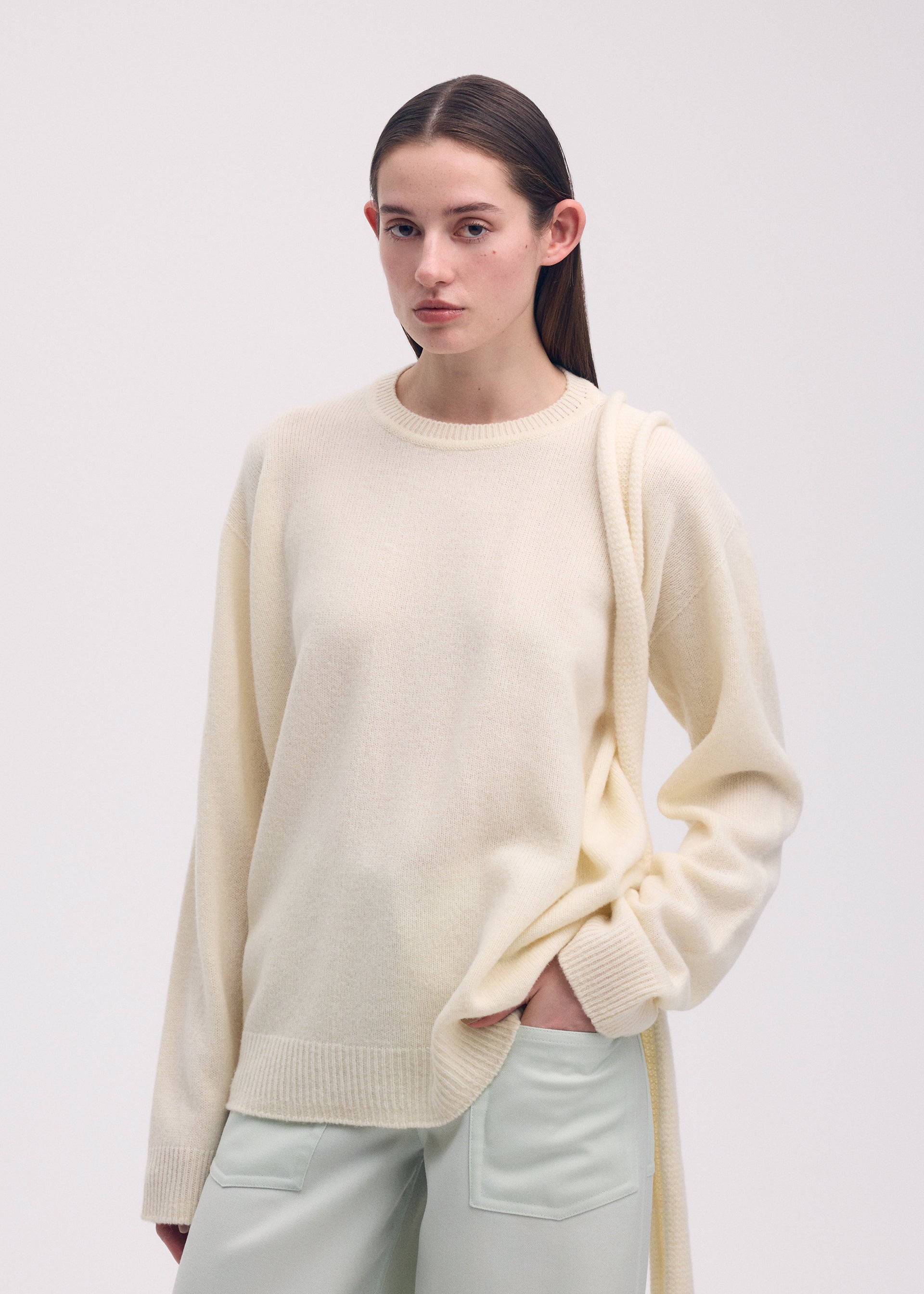 A model wears the ISSEY MIYAKE BACKPACK KNIT top.